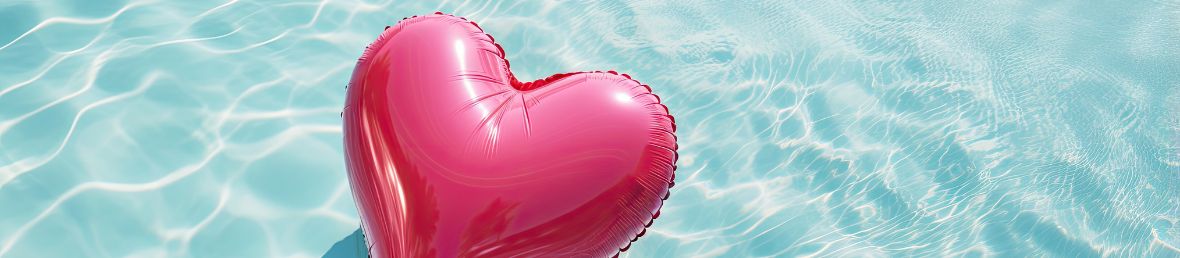 ballon en coeur rose qui flotte dans une piscine
